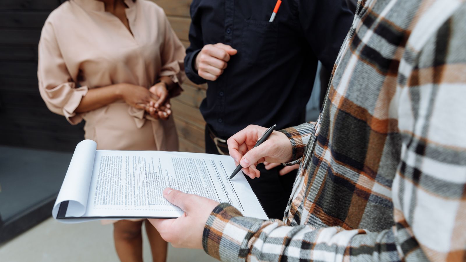 People reviewing and signing a rent agreement outdoors